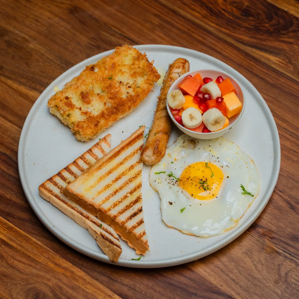 Breakfast plate with fried egg, sausage, fruit bowl and grilled toast at Dear Breakfast, Pokhara